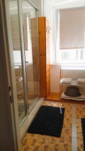 a bathroom with a shower and a black rug at Nerezine CENTRUM apartmán pro 3 osoby in Nerezine +18 photos