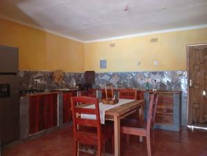 una cucina con tavolo e sedie in una stanza di Capricorn by Quest-Cape Maclear a Chibotero
