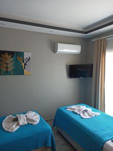 a room with two beds with towels on them at Başar hotel in Erdemli