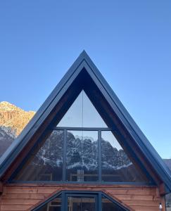 a window of a house with mountains in the background at SeSam Villas in Theth