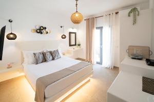 a white bedroom with a bed and a window at Dauti Gold Suites in Vóthon