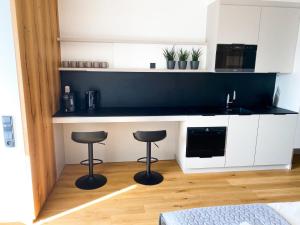 a kitchen with two stools and a counter with a microwave at Studio Palace 404 in Špindlerův Mlýn