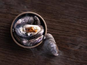 a bowl filled with aubergines on a wooden table at Hotel Arctic in Ilulissat