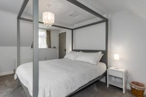 - une chambre avec un lit blanc à baldaquin en métal dans l'établissement Lavender Cottage, à Charlemont