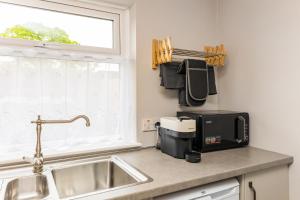 un comptoir de cuisine avec un évier et un micro-ondes dans l'établissement Lavender Cottage, à Charlemont 38 autres photos
