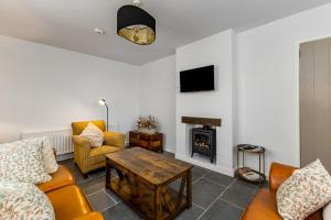 un salon avec un canapé et une cheminée dans l'établissement Lavender Cottage, à Charlemont