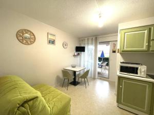a room with a bed and a table with a microwave at Appartement T2 à 50m du lac avec terrasse et piscine à Vieux-Boucau - FR-1-379-173 in Vieux-Boucau-les-Bains