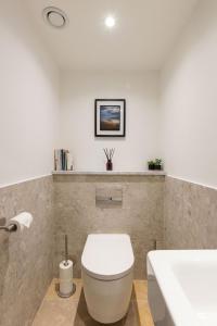 a bathroom with a white toilet and a sink at Owh Studio By The Butler Collection in Arundel +20 photos
