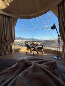 a bedroom with a large window with a table and chairs at Le dôme de Jèpo in Ilonse