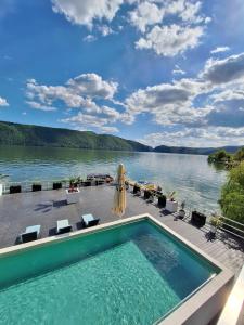 a swimming pool with a view of a lake at Pensiunea Sunshine in Eşelniţa +55 photos