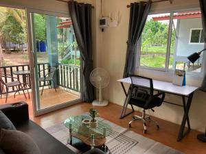 a living room with a desk and a table at Grey Garden in Thong Sala