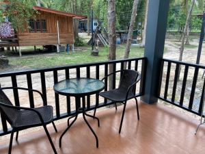 a patio with two chairs and a table on a balcony at Grey Garden in Thong Sala