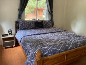 a bedroom with a bed with a blue comforter and a window at Grey Garden in Thong Sala