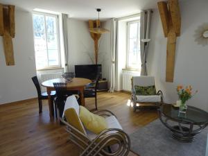 a living room with a table and a dining room at Le Richelieu "Côté sud" Appartement 302 in La Bourboule