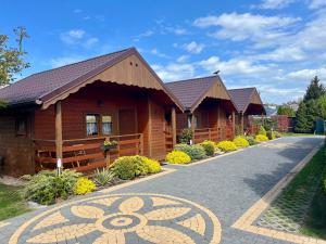 a row of wooden cottages on a road at Domki i Pokoje u Asi in Stegna +10 photos