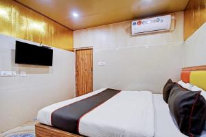コルカタにあるHotel O Shree Krishna Internationalのベッドと薄型テレビのある寝室