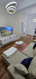 a living room with a couch and a flat screen tv at Bahr DELUX App & Suite in Ulcinj