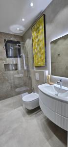 a bathroom with a toilet and a sink and a shower at Bahr DELUX App & Suite in Ulcinj