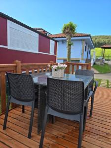 a patio with a table and chairs on a deck at camping Pradon in Arnuero