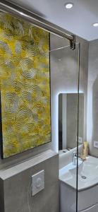 a bathroom with a large yellow painting on the wall at Bahr DELUX App & Suite in Ulcinj