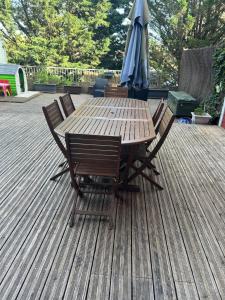 a wooden table with chairs and an umbrella on a deck at Maison Villa in Chenôve