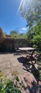 ein Picknicktisch und zwei Bänke in einem Garten in der Unterkunft Gartenwohnung in Norden
