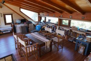 comedor con mesa y sillas y biblioteca en Green House B & B, en Villa La Angostura
