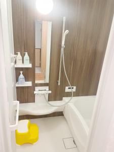a bathroom with a tub and a sink and a shower at Kasukabe raku house in Kasukabe