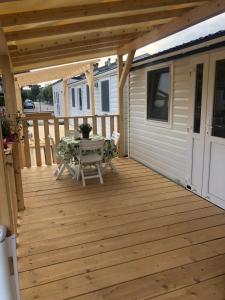 a large wooden deck with a table on it at Tiny house on the beach in Lido di Classe