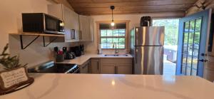 a kitchen with a stainless steel refrigerator and a sink at Recreational Therapy- Private 2 Bedroom with Hot Tub and Firepit in Oakland +8 photos