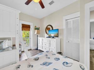 une chambre avec un lit et une commode avec une télévision dans l'établissement Blue Sky Bungalow 156, à Seagrove Beach