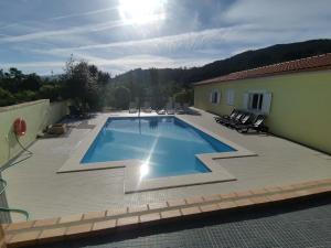 a large swimming pool with chairs and a building at Casa das Marinhas in Caminha