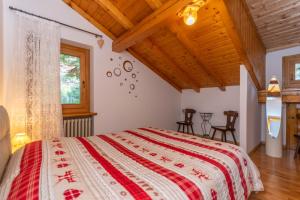 a bedroom with a bed with a red and white bedspread at Casa Fagher in Canale dʼAgordo