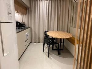 una piccola cucina con tavolo e frigorifero di LOFT Ed Carbono a Blumenau