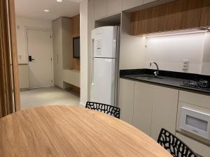 una cucina con tavolo con sedie e frigorifero di LOFT Ed Carbono a Blumenau