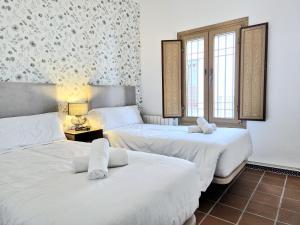 two beds in a room with two windows at BHost - Palace in Córdoba