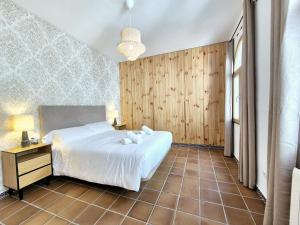 a bedroom with a white bed and a wooden wall at BHost - Palace in Córdoba