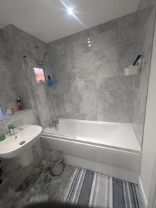 a bathroom with a white tub and a sink at Cosy living space in Orgreave