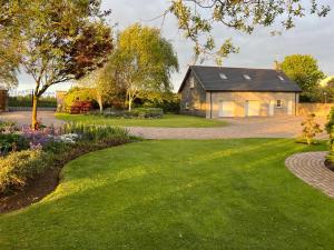 a house with a garden and a driveway at Alpaca Lodge on the North Coast in Coleraine