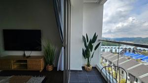 a living room with a balcony with a flat screen tv at Kea Farm Stay in Brinchang
