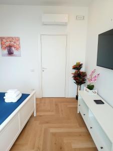 a white room with white furniture and a flat screen tv at La Piazzetta in Veroli