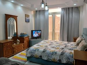 a bedroom with a bed and a television in it at 378 Pyramids St -Two bedrooms Hotel Apartment in Cairo