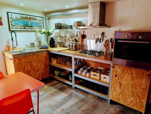 a kitchen with a stove and a counter top at Garage Number 9 Private Urban Loft Apartment with Jacuzzi in Le Dorat in Le Dorat