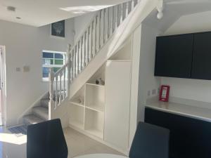 a living room with two chairs and a staircase at Alpaca Lodge on the North Coast in Coleraine