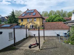 a scooter parked in a courtyard in front of a house at Charmantes helles Zimmer zentrumnah und naturnah in Göppingen