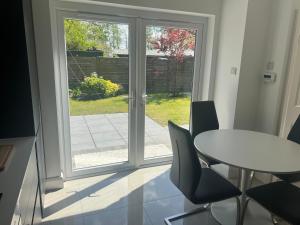 a room with a table and chairs and a sliding glass door at Alpaca Lodge on the North Coast in Coleraine