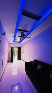 a living room with a blue ceiling and a couch at The Oasis Home in Islamabad