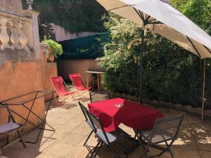 a patio with a table and chairs and an umbrella at Chez Aldo in Ajaccio