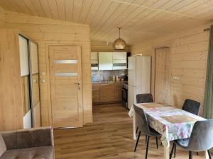 a kitchen with a table and chairs and a refrigerator at Apartement u Jędrusia w ogrodzie in Żywiec