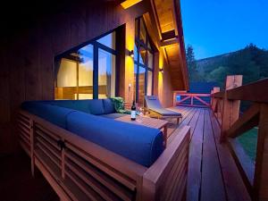sala de estar con sofá azul en una terraza de madera en Chalet Oasis - Luxury 5-Bedroom Chalet with Panoramic Views, en Huty